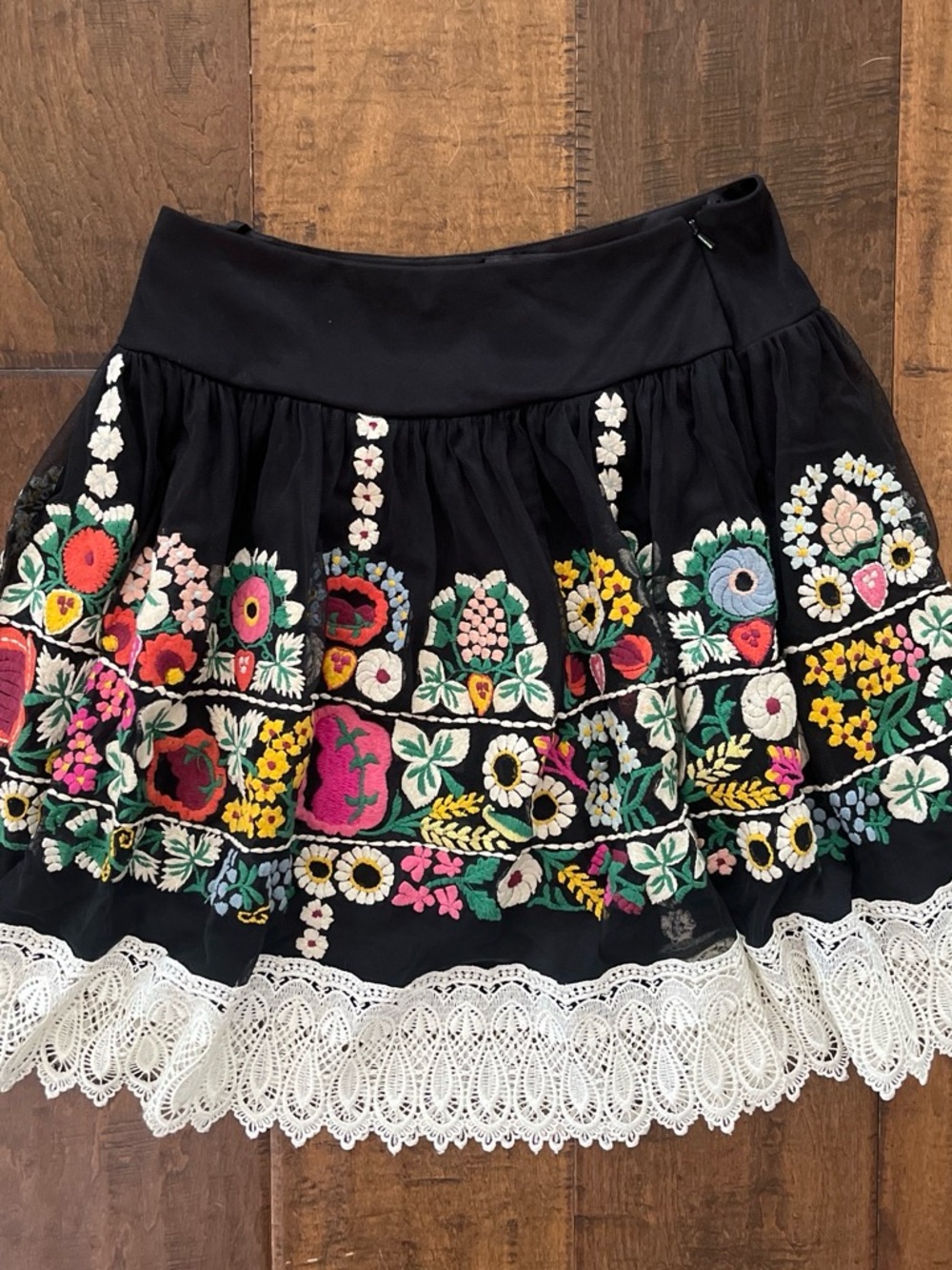 Vintage Collection black mini skirt with floral embroidery and white lace trim.